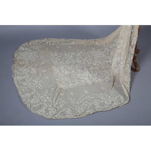 215 - A late 19th early 20th century lace train, the net ground applied with Honiton bobbin lace to the ce... 