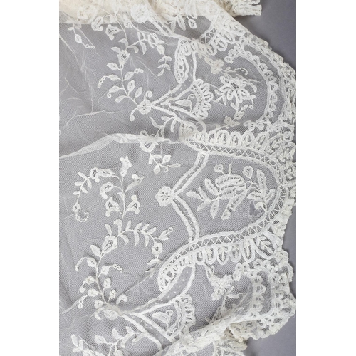 228 - Antique lace: a trained skirt panel in Limerick lace, constructed to cross over, with shaped sides; ... 