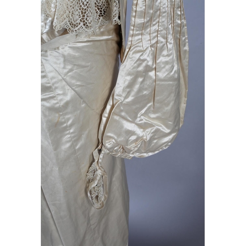 272 - A two-piece cream silk satin ensemble, comprising skirt and bodice, both lined in a pale salmon cott... 