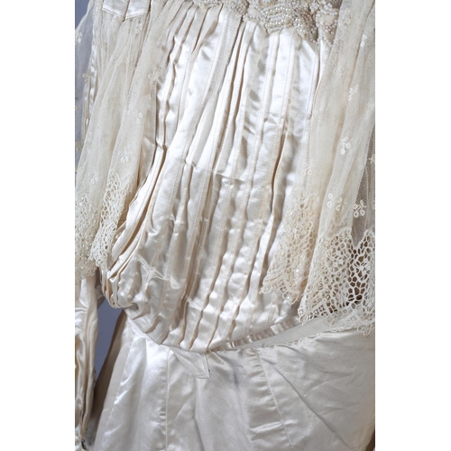 272 - A two-piece cream silk satin ensemble, comprising skirt and bodice, both lined in a pale salmon cott... 