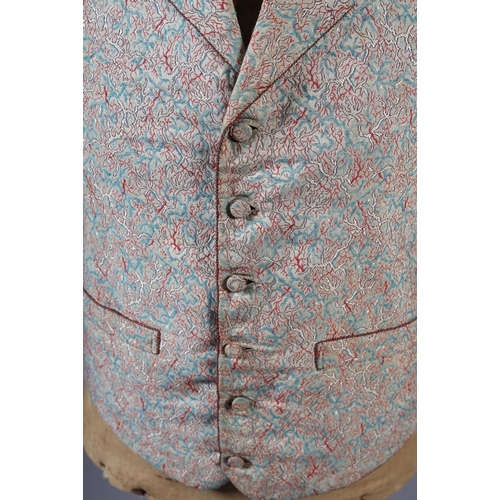 292 - A mid19th century waistcoat for a young gentleman, woven with red and turquoise on a cream ground, t... 