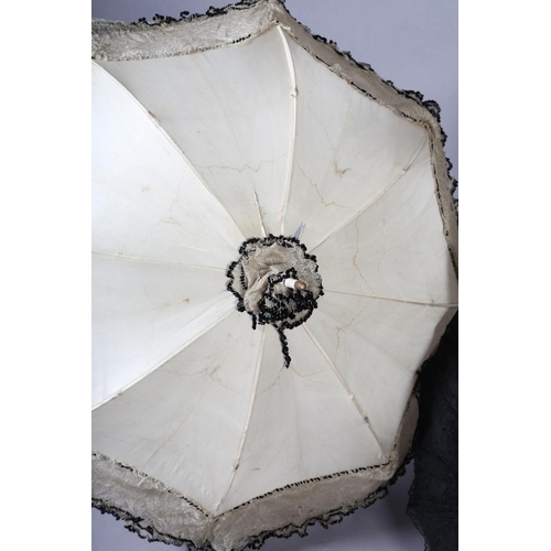 293 - Late 19th century parasols, large, the first with simple wood shaft, decorative tassel and black lac... 