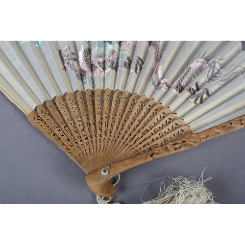 58 - A 20th century Chinese carved sandalwood fan, the white cotton gauze leaf embroidered in pastel silk... 