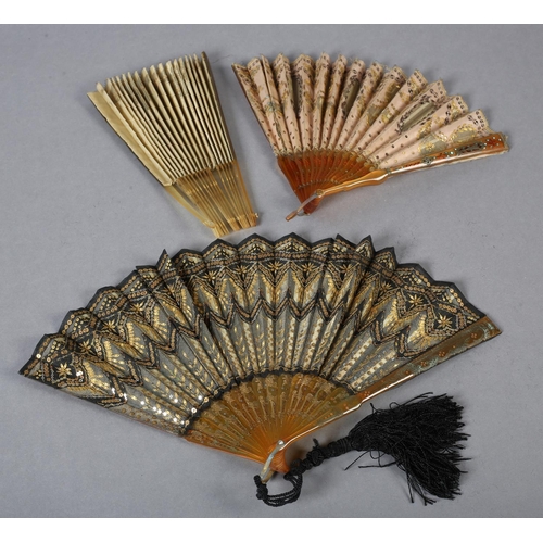 72 - c.1900, three horn fans, the first mounted with gold lamé fabric and extravagantly  embroidered with... 