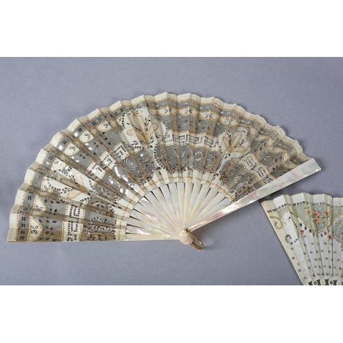 73 - A good c.1900 light pink mother of pearl fan, the leaf of gold lamé overlaid with cream silk, cut aw... 