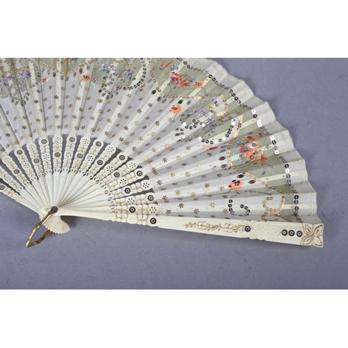 73 - A good c.1900 light pink mother of pearl fan, the leaf of gold lamé overlaid with cream silk, cut aw... 