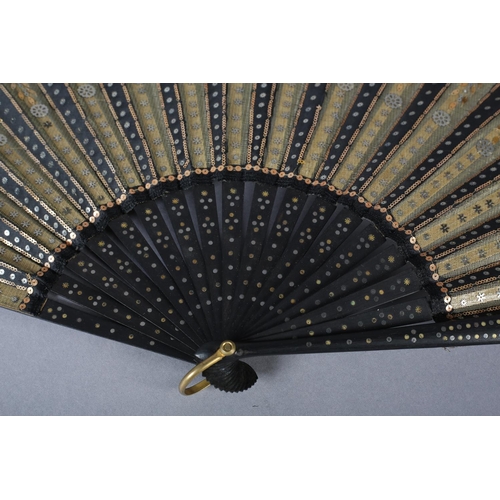 74 - A good and fairly large sequined fan, c 1900, the gold lamé leaf overlaid on alternate folds with bl... 