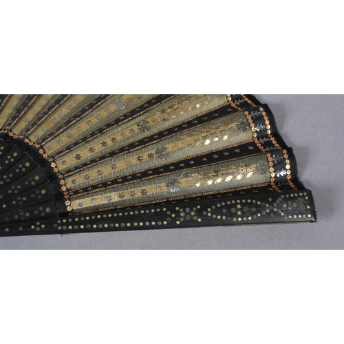 74 - A good and fairly large sequined fan, c 1900, the gold lamé leaf overlaid on alternate folds with bl... 