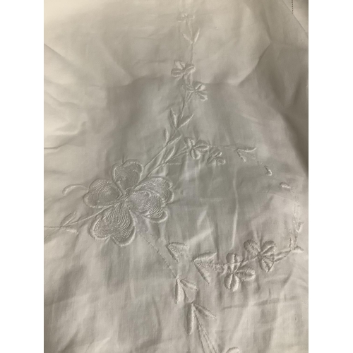 186 - A very large and attractive white linen bedcover, embroidered in white, with flowers, and edged in c... 