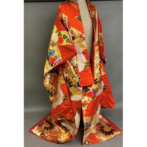 195 - An elaborate Japanese wedding kimono, 19/20th century, vibrant red silk embroidered in gold, excepti... 