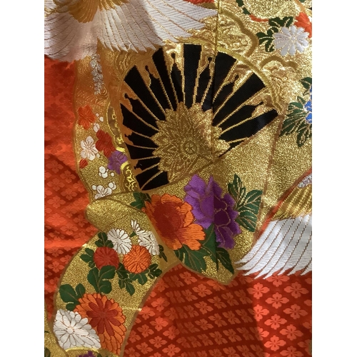 195 - An elaborate Japanese wedding kimono, 19/20th century, vibrant red silk embroidered in gold, excepti... 