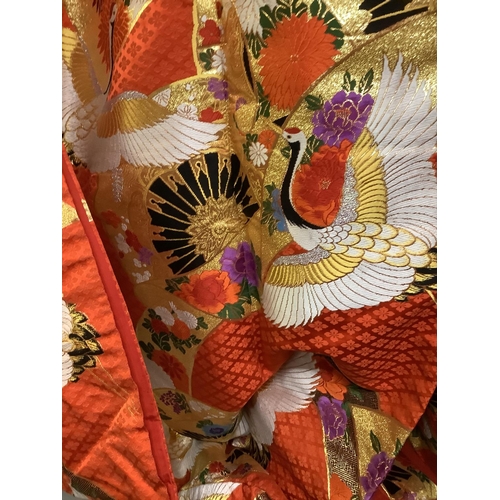 195 - An elaborate Japanese wedding kimono, 19/20th century, vibrant red silk embroidered in gold, excepti... 