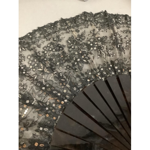 24 - A last quarter 19th century black machine lace fan mounted on sturdy tortoiseshell sticks and ribs, ... 