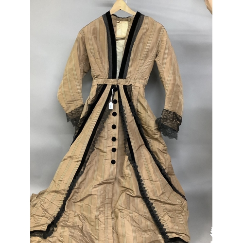 280 - An 1880’s silk gown, a biscuit shade with stripes, bustle back, fitted bodice lined in cream glazed ... 