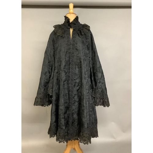 337 - A black embossed silk late Victorian cape, three-quarter length, trimmed with black machine lace and... 