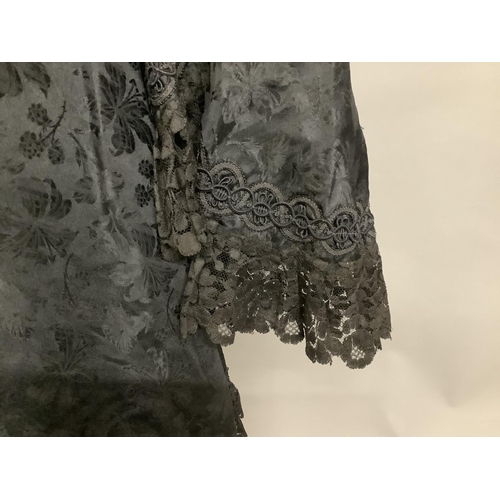 337 - A black embossed silk late Victorian cape, three-quarter length, trimmed with black machine lace and... 