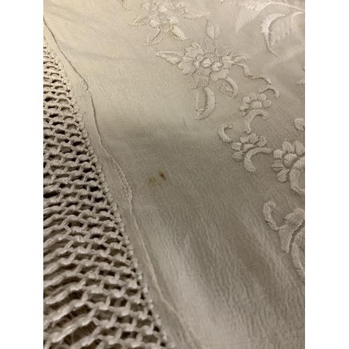 347 - An embroidered silk Canton shawl, cream on cream, with macramé fringe, each corner with a large flor... 