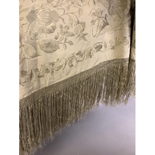 348 - A large19th century canton embroidered beige silk shawl, fringed, with a deep border of large flower... 