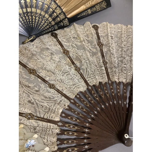 71 - A large late 19th century fan, the dark wood monture shaped, gilded and silvered, the gorge arranged... 