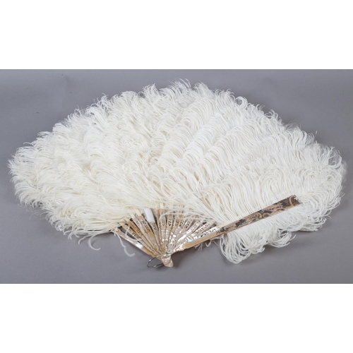 99 - A large black ostrich feather fan, the monture of tortoiseshell, the upper guard fitted with a detac... 