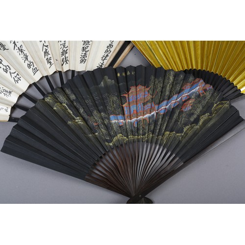 43 - Three 20th century Oriental fans, with wood montures and paper leaves, the first depicting a colourf... 