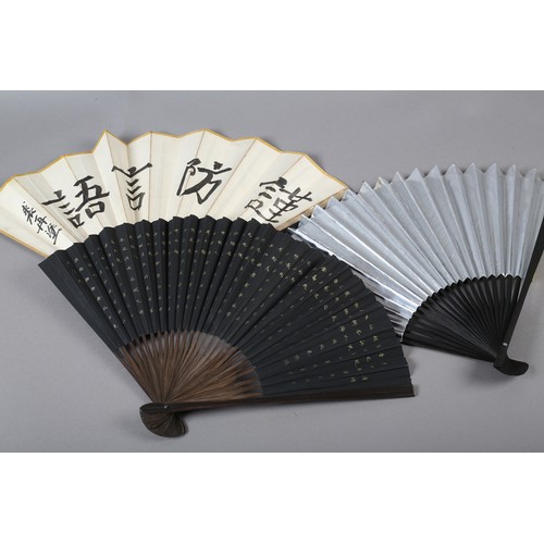 43 - Three 20th century Oriental fans, with wood montures and paper leaves, the first depicting a colourf... 