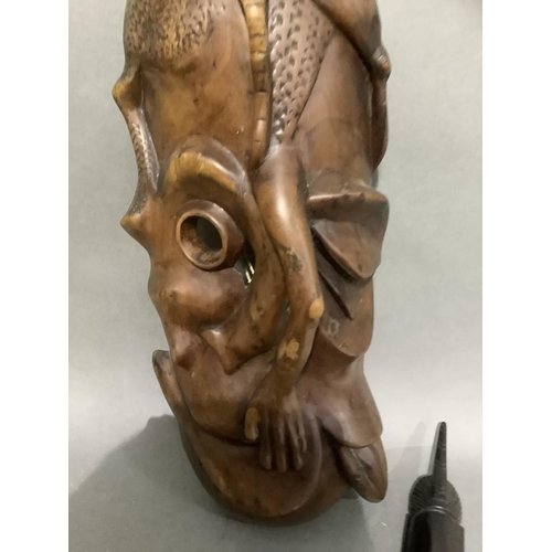 107 - A large carved African mask and a smaller ebonised mask