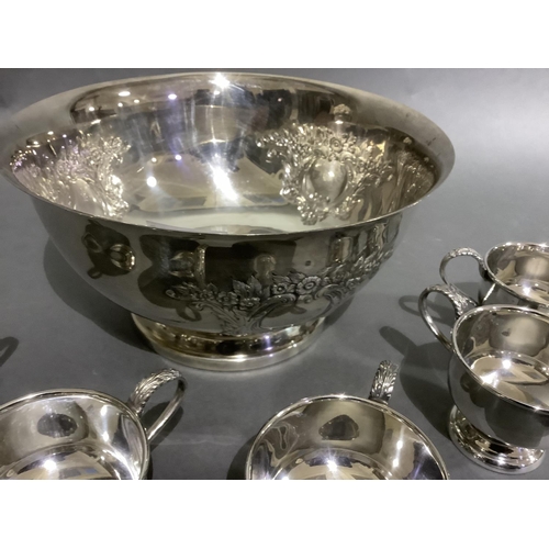 141 - A good silver plated punch bowl with six cups and ladle, embossed with flowers and blind cartouche,