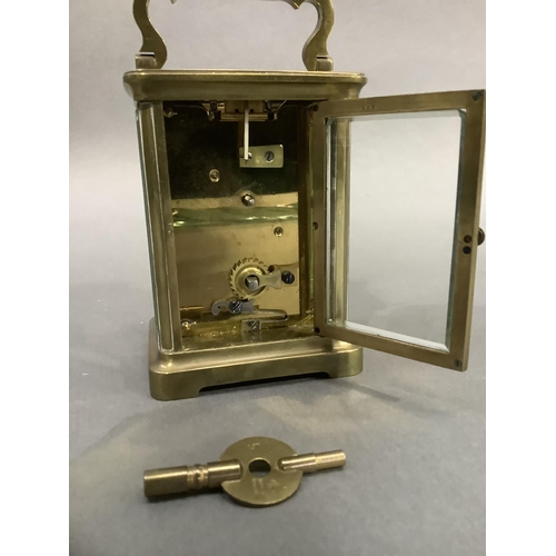 50 - A brass carriage clock circa 1900 having a gilt face with porcelain dial and with Arabic numerals in... 