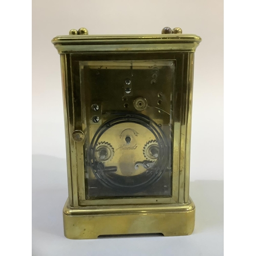 20 - A late 19th century brass carriage clock,  movement striking on a gong,  the enamelled dial with bla... 