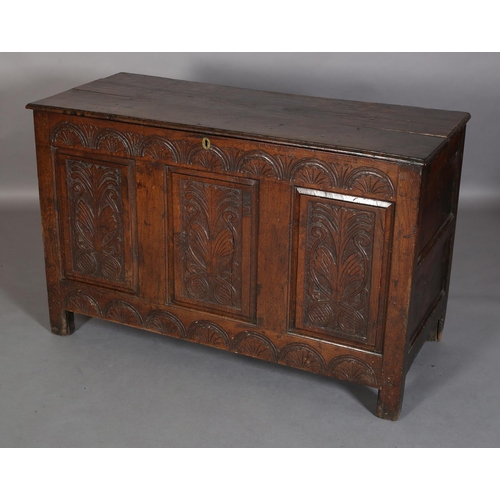 351 - AN 18TH CENTURY OAK JOINED CHEST, the planked top with slot in fastening demi-lune carved frieze and... 