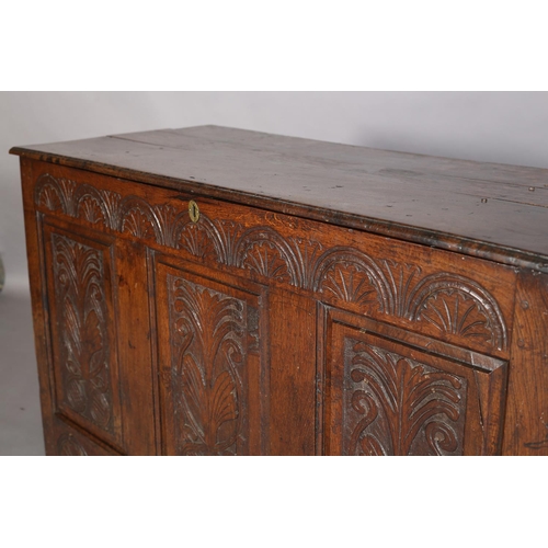 351 - AN 18TH CENTURY OAK JOINED CHEST, the planked top with slot in fastening demi-lune carved frieze and... 