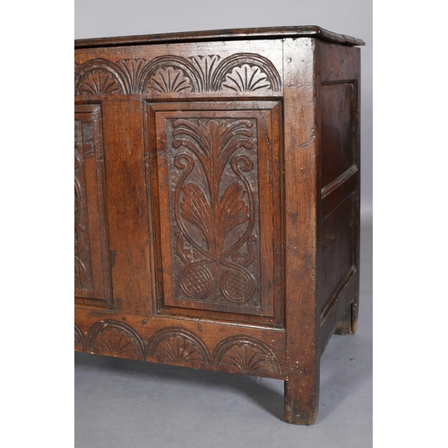 351 - AN 18TH CENTURY OAK JOINED CHEST, the planked top with slot in fastening demi-lune carved frieze and... 