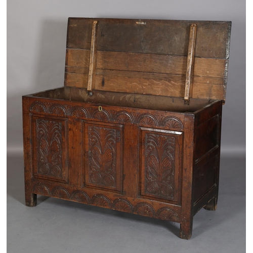 351 - AN 18TH CENTURY OAK JOINED CHEST, the planked top with slot in fastening demi-lune carved frieze and... 