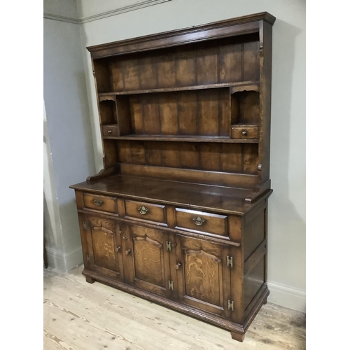 340 - A good reproduction oak dresser and rack having a moulded cornice over planked back with shelves and... 