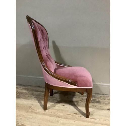 364 - A reproduction Victorian mahogany nursing chair having encircling frame, pink buttoned upholstery an... 