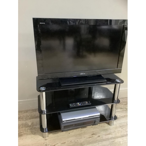 90 - A Sony Bravia television with glass stand, Alba DVD player and VHS player