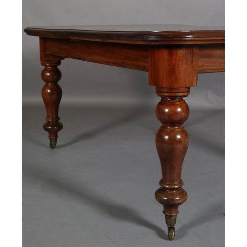 393 - A Victorian mahogany extending dining table, with two leaves, on baluster turned legs with brass cap... 