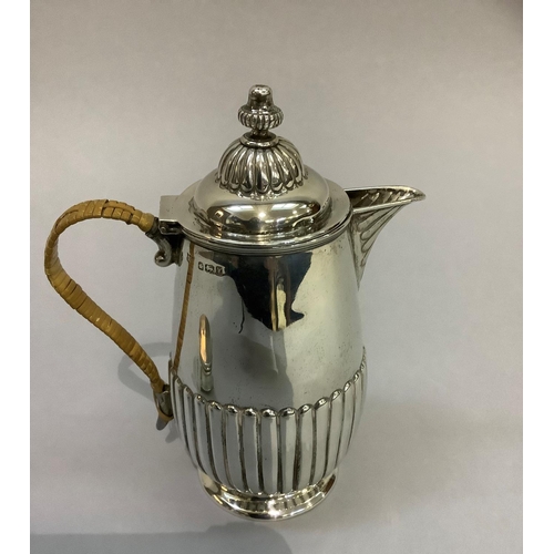 220 - A Victorian silver hot water jug, reeded base and lid with acorn finial and wicker covered handle, h... 