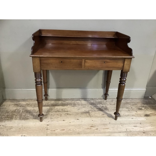 376 - A 19th century mahogany wash stand having a three-quarter gallery above two drawers to the apron and... 