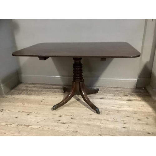 386 - A 19th century mahogany breakfast table having a rectangular tilt top, on turned pedestal and four d... 