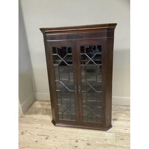 395 - A 19th century mahogany and glazed corner cabinet having a moulded cornice above two glazed tracery ... 