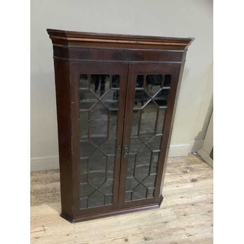 395 - A 19th century mahogany and glazed corner cabinet having a moulded cornice above two glazed tracery ... 