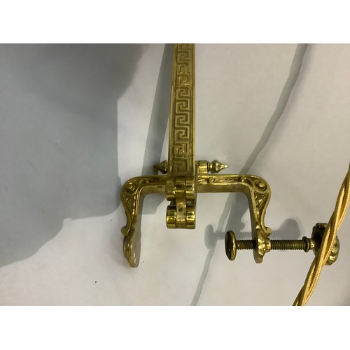 44 - A Victorian gilt metal reading lamp on a hinged and folding arm with clamp fixing, complete with gre... 