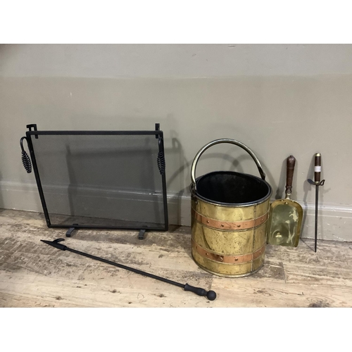 197 - A brass and copper coal bucket together with brass shovel and poker, a reproduction black fire guard... 