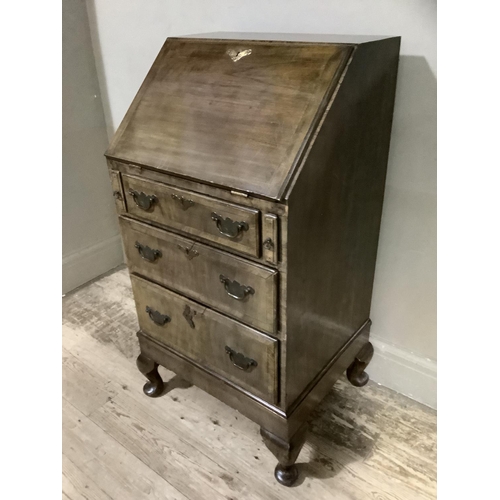 338 - A lady's walnut bureau having a fall front fitted interior with small drawers and pigeon holes above... 