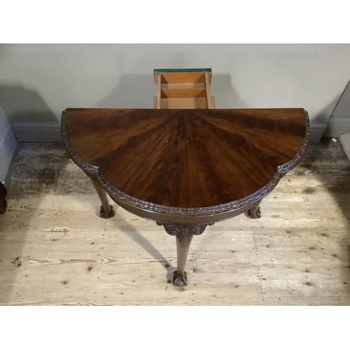 385B - A mahogany card table of scalloped outline having a fold over top lined in baise and on three cabrio... 