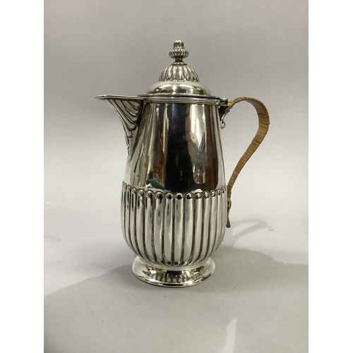 220 - A Victorian silver hot water jug, reeded base and lid with acorn finial and wicker covered handle, h... 