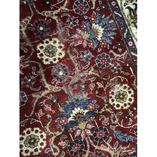 382 - A middle Eastern carpet having a crimson ground filled with flowering vines in ivory, blue, rose and... 