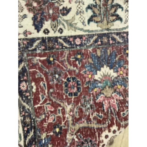 382 - A middle Eastern carpet having a crimson ground filled with flowering vines in ivory, blue, rose and... 